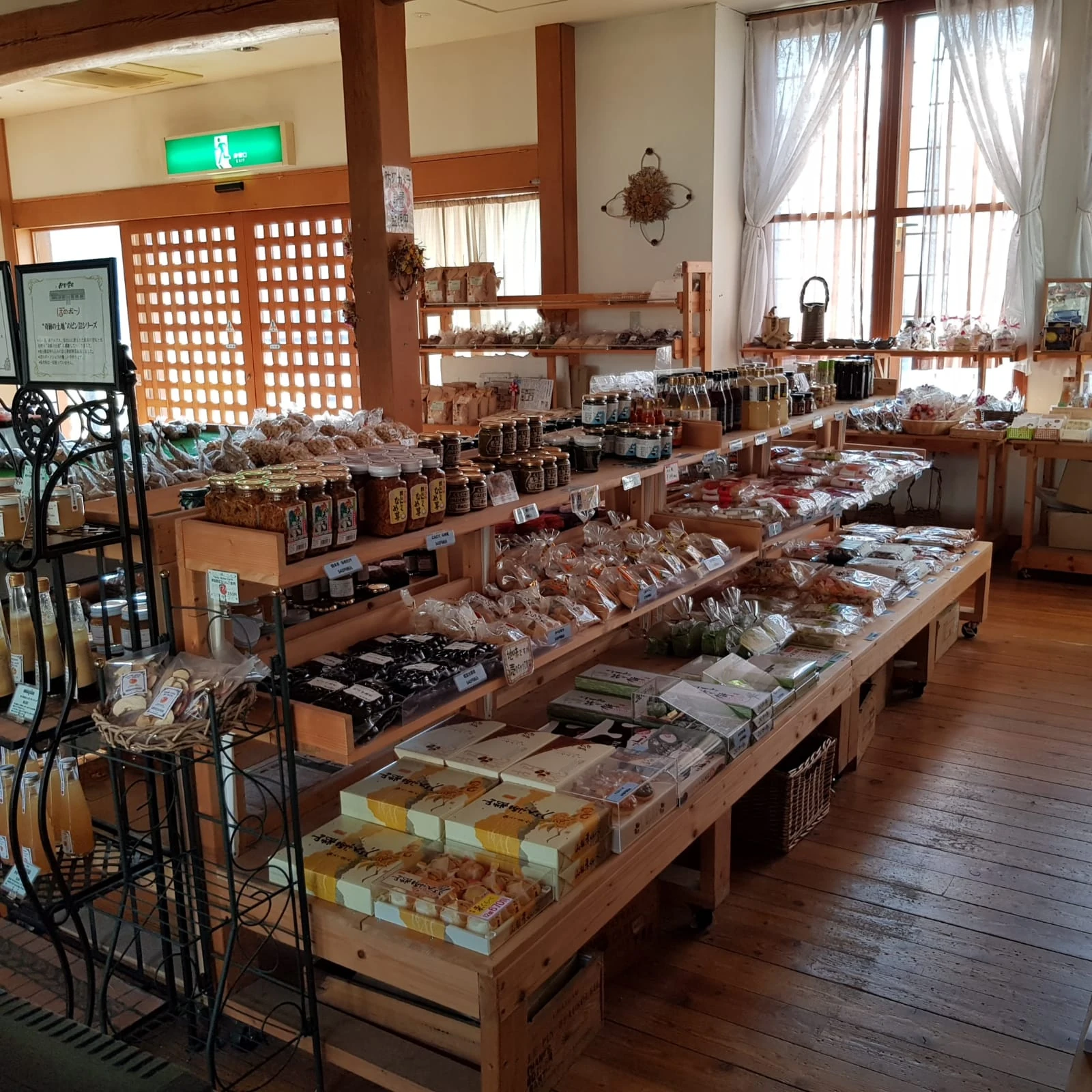 Shelves and display tables of local products inside a timber-lined shop.